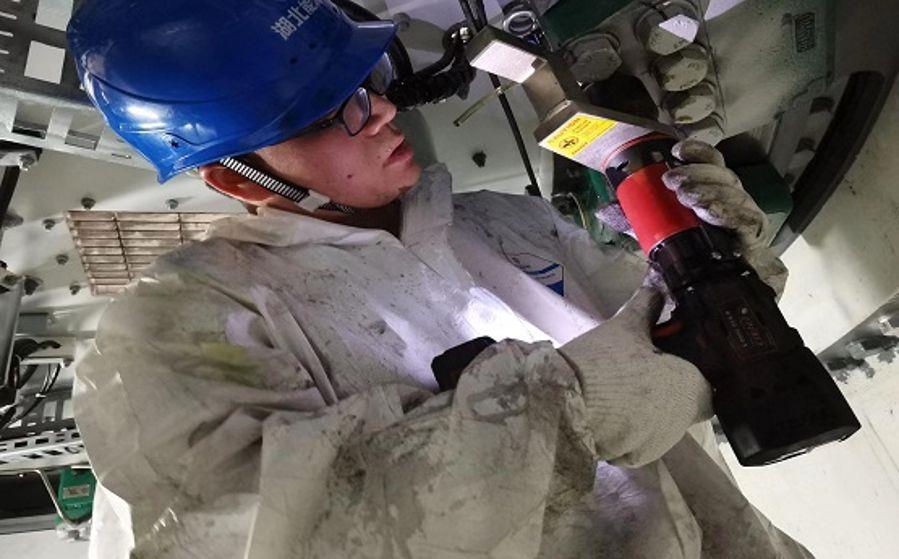 運維人員袁才波正在狹小的空間內(nèi)打力矩(攝影:張鍵鍵) 運維人員袁才波正在狹小的空間內(nèi)打力矩(攝影:張鍵鍵)